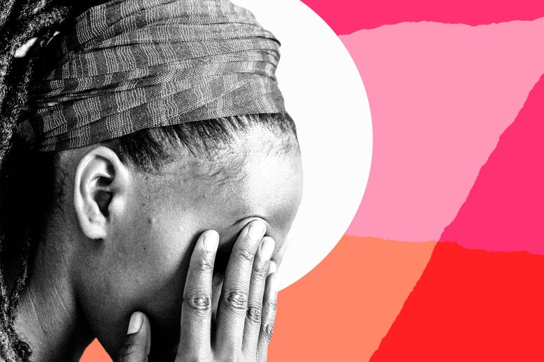 A woman holds her head in her hands.